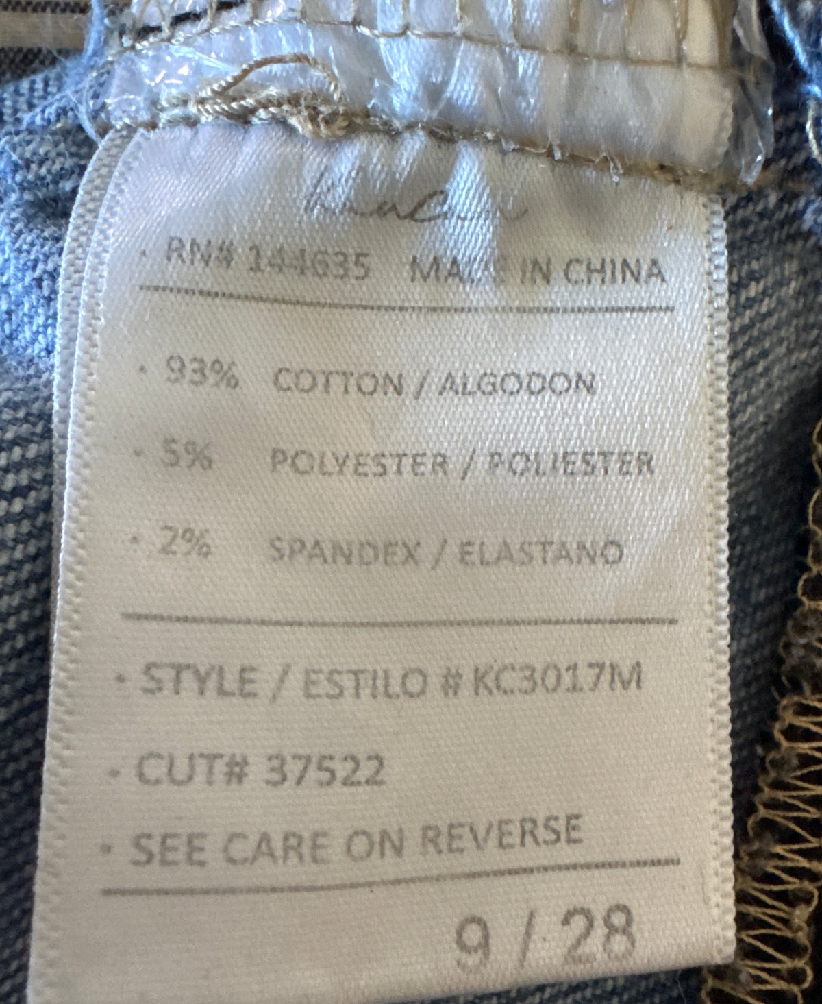 Jeans fabric label showing size 9/28 and fabric composition